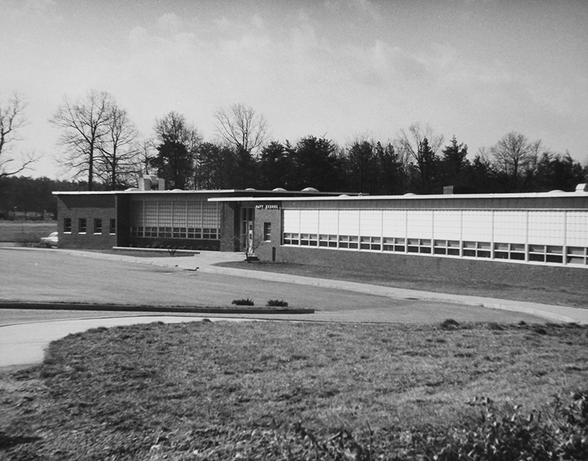 Black and white photograph of the front exterior of Navy Elementary School showing the original main entrance to the building.