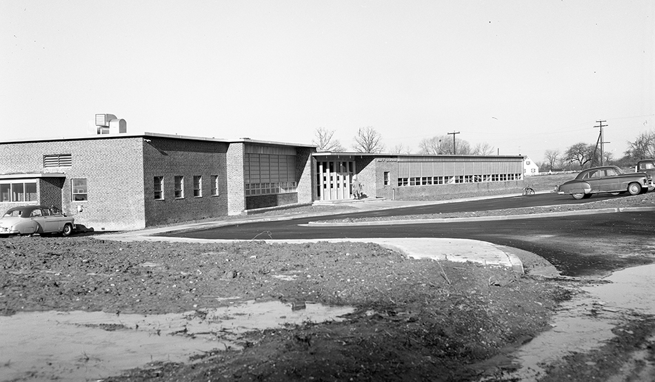 Black and white photograph of the original front entrance of Navy Elementary School. The entrance faced West Ox Road and had a small parking lot in front.